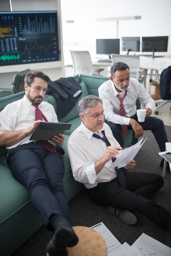 Mastering the First Impression: Your intriguing post title goes here Three businessmen analyzing financial reports in a modern office setting.
